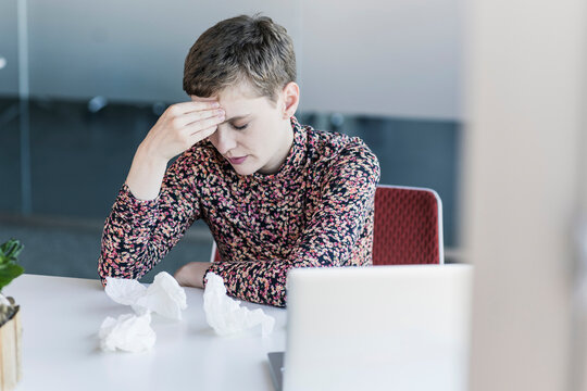 Ill businesswoman sitting at desk in office