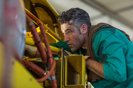 Mechanic in hangar repairing light aircraft