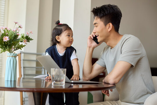 A work-from-home dad takes care of his baby while working
