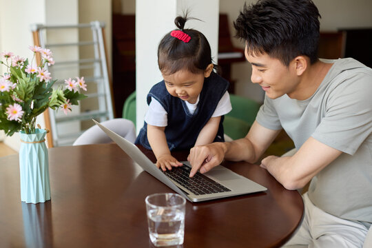 A work-from-home dad takes care of his baby while working