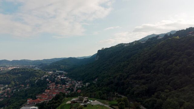 Drone view of the town of Alzo, part of Pella, nestled in the green hills above Lake Orta in Piedmont, Italy. Aerial forward, copy space