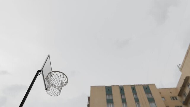 Hyper-realistic 3D animation of a basketball hoop from a unique low-angle perspective. See the ball describe a perfect parabola through the hoop and net in this high-quality CGI rendering.