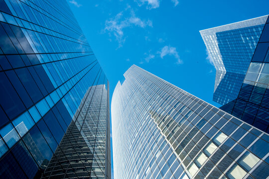 Modern skyscraper architecture of glass reaches upward into the sky in Paris La Defense financial district creating a clean urban backdrop