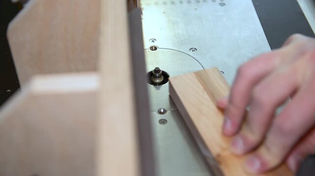 Skilled carpenter flexing his muscles while using router at workplace. Wood router in action smoothly cutting into a wooden for rounding the corner.