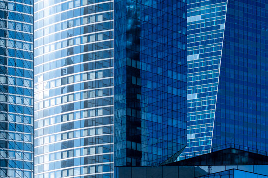 Modern skyscraper architecture with glass facade and reflections in Paris La Defense financial district offering abstract blue city background