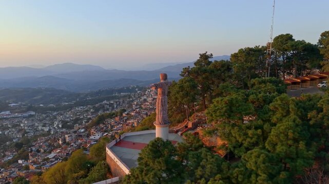 Aerial view of the Monumental Christ of Taxco overlooking the town of Taxco at sunset with a fine mist, Guerrero state, Mexico