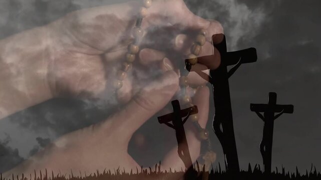 Bare hands over 3 crosses on hill starting prayer sliding rosary counting beads while fog drifting