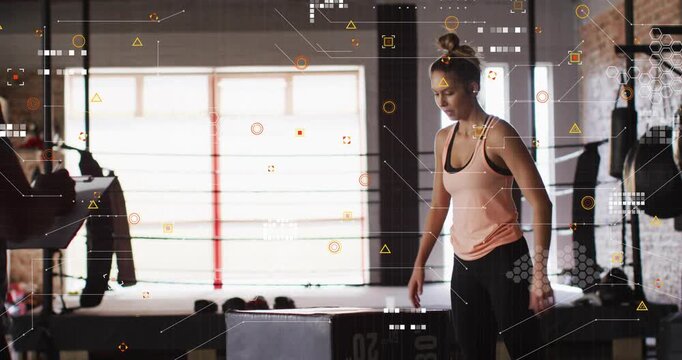 Woman adjusting wrist wrap and launching over plyo box for explosive training, HUD tracking motion