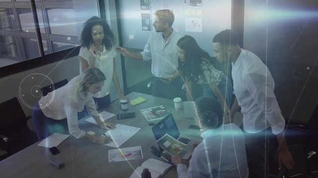 Marketers at table, moderator gesturing, sparking layout debate, marking mockups, overlays sweeping