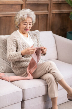 Old lady knitting on the couch
