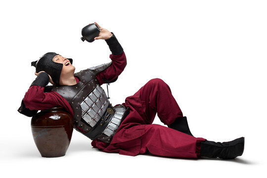Humorous studio shot: armored ancient soldier with a jar of wine