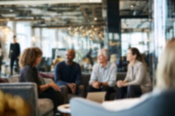 Fototapeta premium Blurred Diverse business team collaborating in modern office meeting, casual conversation