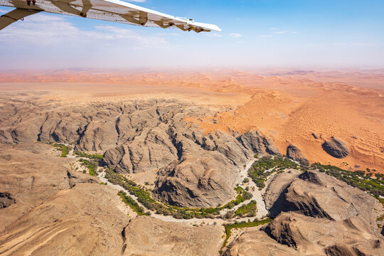 View from a Cessna airplane showing part of the wing and the vast Namib Desert below