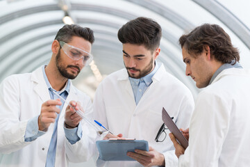 Fototapeta premium three men in labcoats in discussion