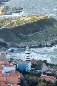 Aerial view of a striking black and white lighthouse standing tall against the turbulent sea, with the historical park of Sile Feneri offering a tranquil contrast, Istanbul, Istanbul, Turkey.