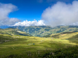 Naklejka premium Mountain pastures and clouds above alpine valleys in Les Contamines-Montjoie, France