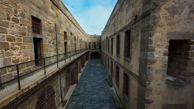 Aerial view of weathered stone walls and arched windows create a stark, geometric pattern within the Chateau du Taureau, Plouezoc'h, Bretagne, France.
