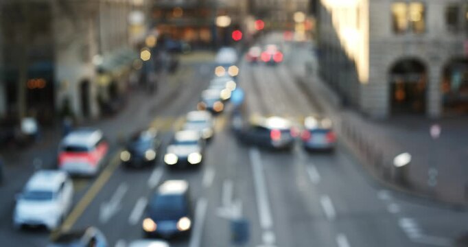 Blurry, abstract, high angle aerial view of car and pedestrian traffic on a busy urban street. Evening sunlight, real time video, bokeh effect highlights