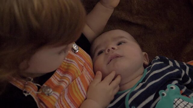 Soeur avec son petit fr&egrave;re nouveau-n&eacute; dans les bras