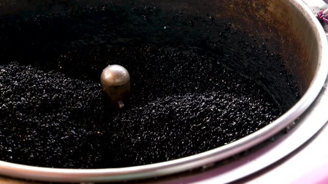 roast chestnuts view of cooking chestnuts in a roasting machine at a night food market in a Chinatown. Roasted chestnuts are a popular street food in Asia.