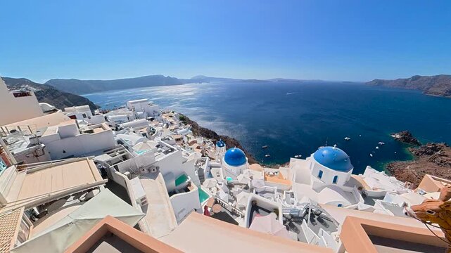 Iconic blue-domed churches and white buildings of Oia, Santorini, Greece, overlooking the Aegean Sea and caldera cliffs, a popular tourist destination.