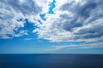 Obraz premium Minimalist summer background of blue Adriatic sea and dramatic cloudy sky in Montenegro. Mediterranean travel and freedom concept with copy space.