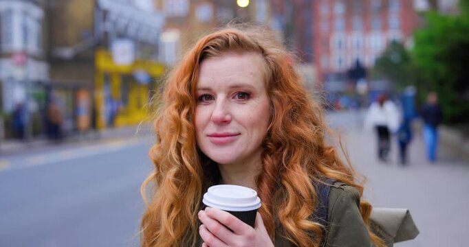 Beautiful redhead woman with freckles drinking coffee