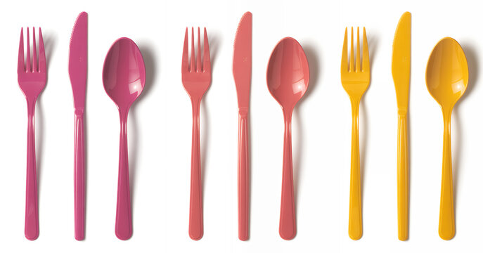 Colorful plastic utensils on white background pink yellow spoons