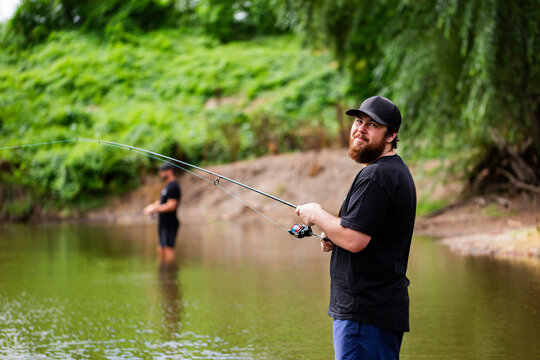 Australian men fishing together in river on summers day