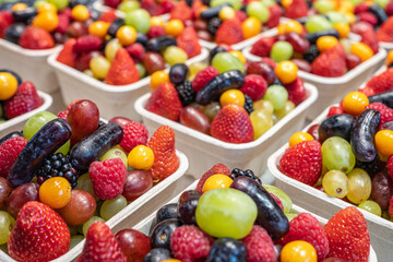Obraz premium Assorted paper containers of berries for sale at a market. Healthy fruits