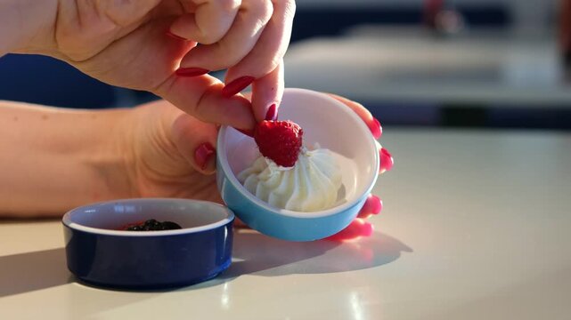 dip raspberries in cheese closeup of rotating yogurt with raspberries