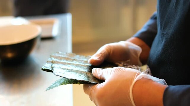 chef preparing sea urchin rolls Chef hands preparing sushi roll, squeeze out cream cheese