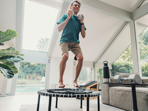 Active person working out on trampoline indoors with fitness equipment