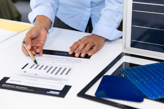 Professional showing energy consumption chart and solar panel at office