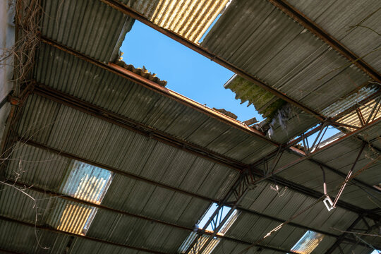 Asbestos cement roof with damaged eternit panels, hazardous material removal, environmental risk concept, industrial building renovation, toxic exposure danger, construction safety and pollution issue