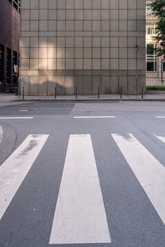 Bold crosswalk street asphalt markings form urban pattern lines on empty pavement space creating minimal road safety background for copy