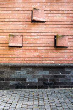 Brick wall facade with windows in empty urban architecture showing texture over pavement space as minimal background for branding copy