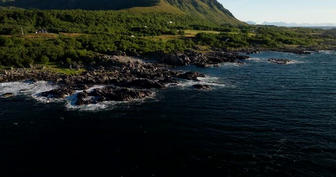 Aerial orbit of waves crashing on rocky coastline at Uvaershula near Stokmarknes Norway