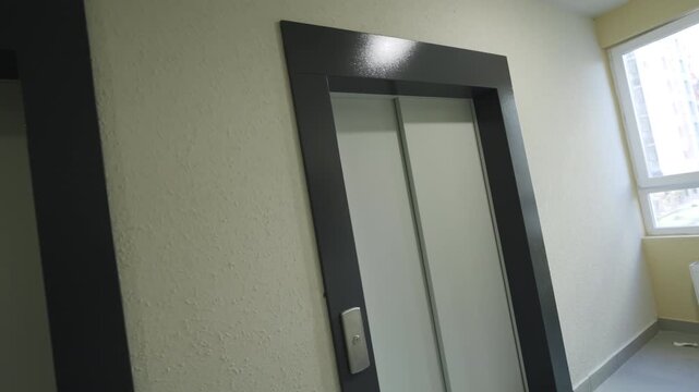 Staircase hall with large window and elevators available for residents of building. Space designed for comfortable vertical circulation