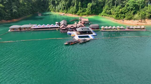 Aerial view of a floating resort on the turquoise waters surrounded by dense green forests, Khao Sok, Surat Thani, Thailand.