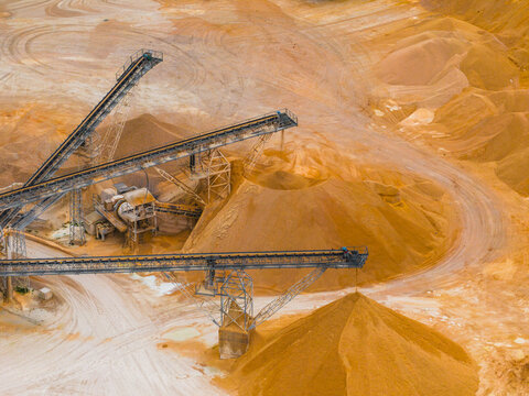 Aerial view of the golden earth being moved by the mechanical arms and the winding roads, Arsoli, Lazio, Italy.