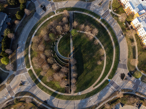 Aerial view of a roundabout featuring a central park with trees and curved architecture, The Colony, Texas, United States.