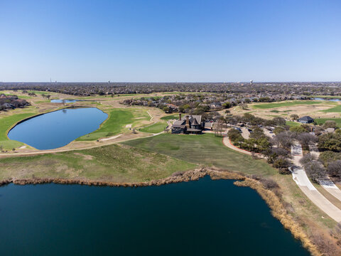 Aerial view of the tranquil lake reflecting the clear sky, nestled amidst the golf course, McKinney, Texas, United States.
