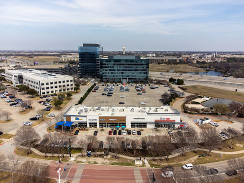 Aerial view of modern buildings and a busy parking lot under a cloudy sky, Frisco, Texas, United States.