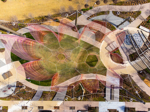 Aerial view of a geometrically fascinating playground canopy casts shadows on the green grass below, creating a mesmerizing pattern of light and shade, Frisco, Texas, United States.