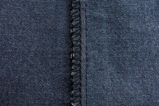 Overlock seam detail on dark fabric inside garment close up