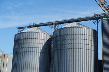 Massive cylindrical storage silos connected by elevated conveyor system © Aleksandr Fedosov