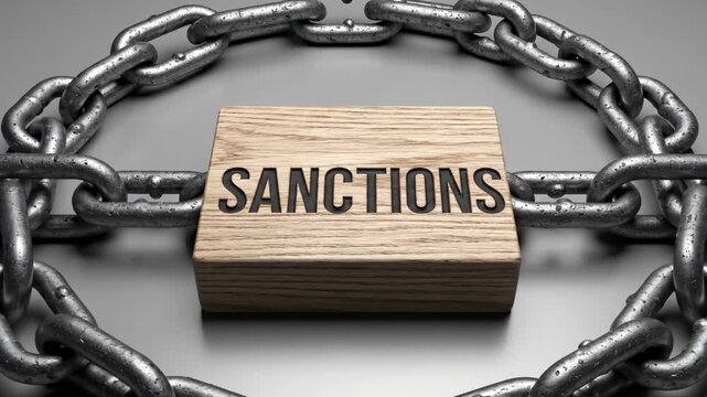 Wooden block with the word SANCTIONS surrounded by thick metal chains on a gray surface, illustrating the concept of restrictions and limitations in a visually striking manner
