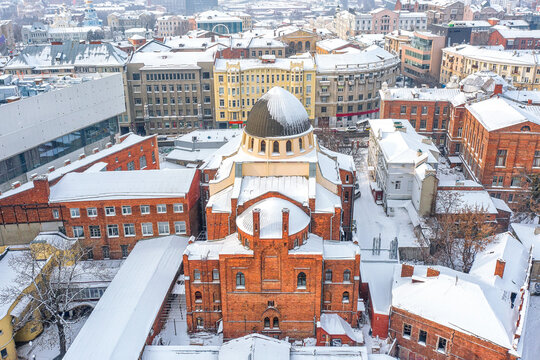 Aerial view of the majestic Kharkiv Choral Synagogue stands out with its red brick facade against the snowy landscape, Kharkiv, Kharkiv Oblast, Ukraine.