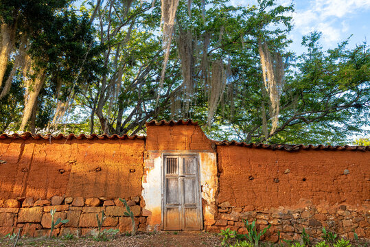 Barichara, Colombia colonial dirt wall with wooden door and trees